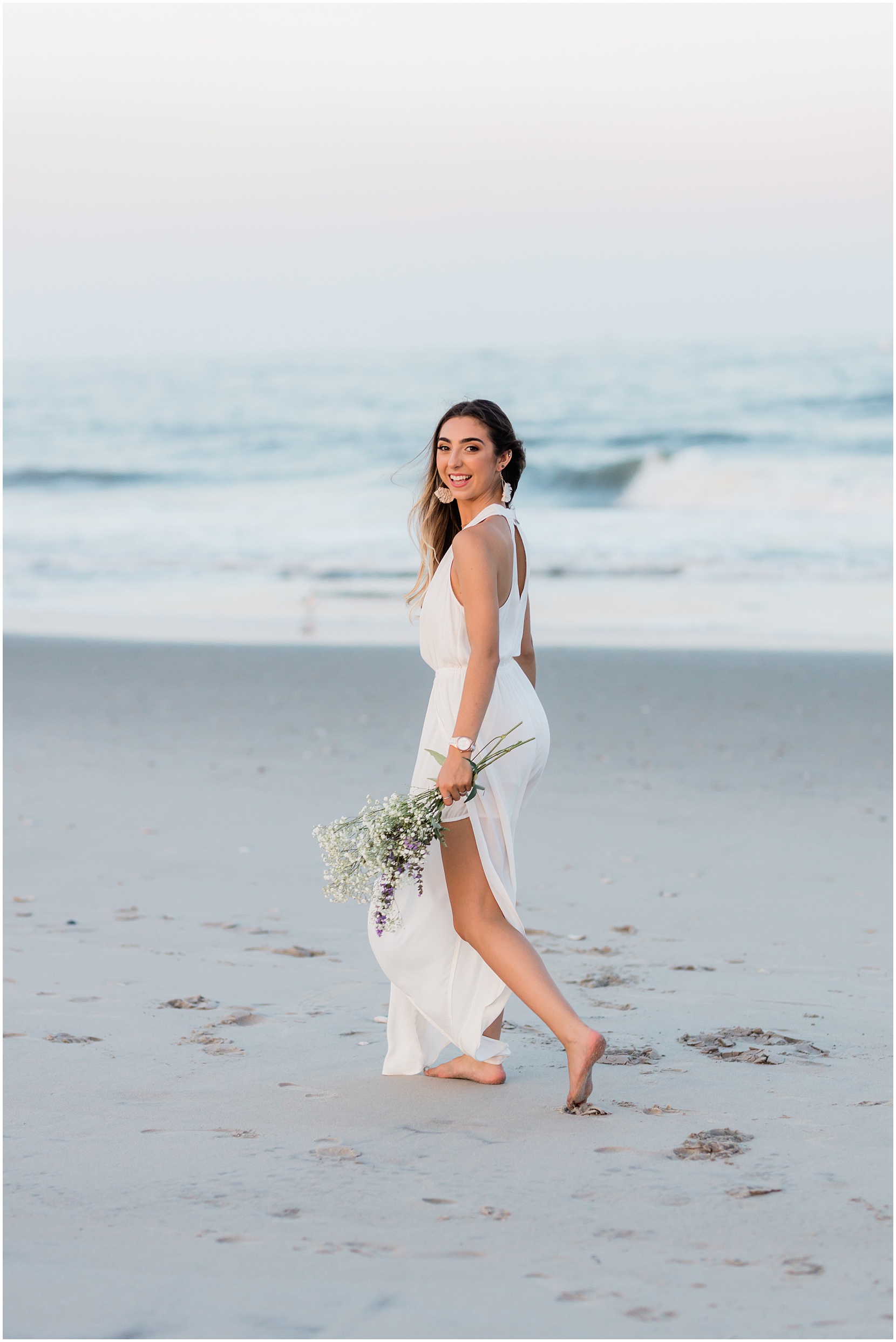 teen girl skipping on the beach with flowers