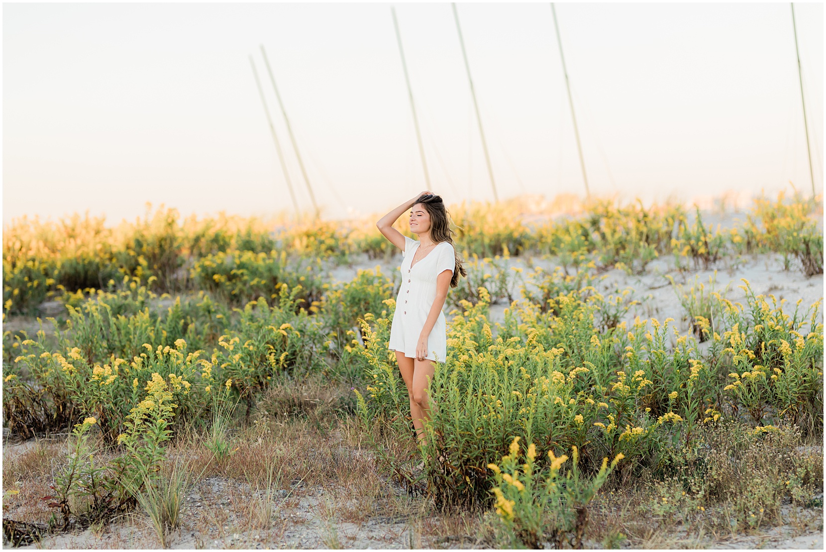 Teen girl posing in a field of yellow flowers on the beach in Ocean City, New Jersey.